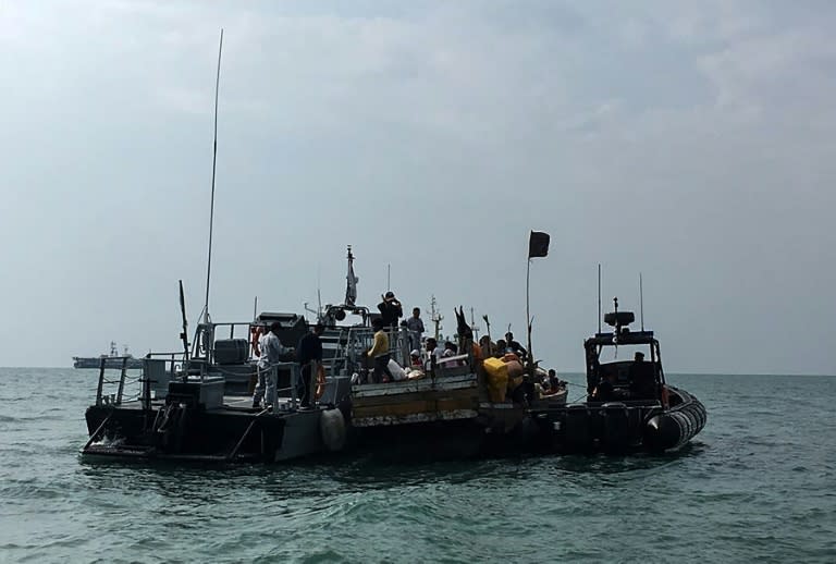 Members of the Malaysian Maritime Enforcement Agency detain the boat (C) carrying Rohingya refugees