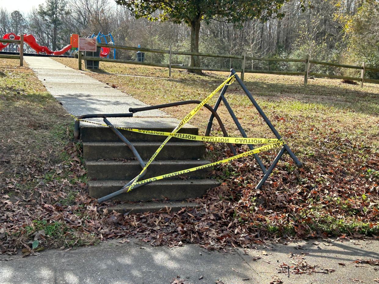 Yellow caution tape is wrapped around the iron railing where a car crashed early Wednesday, Jan. 18, 2023 at Arlington Park in Hopewell. Police said the two occupants of the vehicle were shot prior to the wreck and died at the scene.