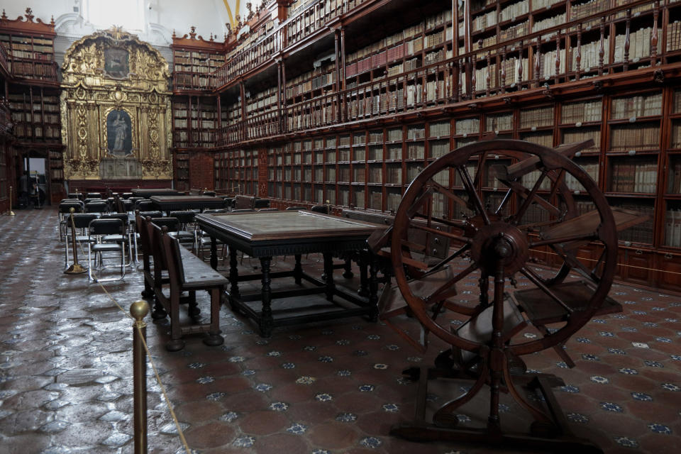 Una pared cubierta de oro que enmarca una pintura de la Virgen María, al fondo, decora el interior de la Biblioteca Palafoxiana, la biblioteca pública más antigua en América, el martes 13 de septiembre de 2022 en la ciudad de Puebla, México. (AP Foto/Pablo Spencer)