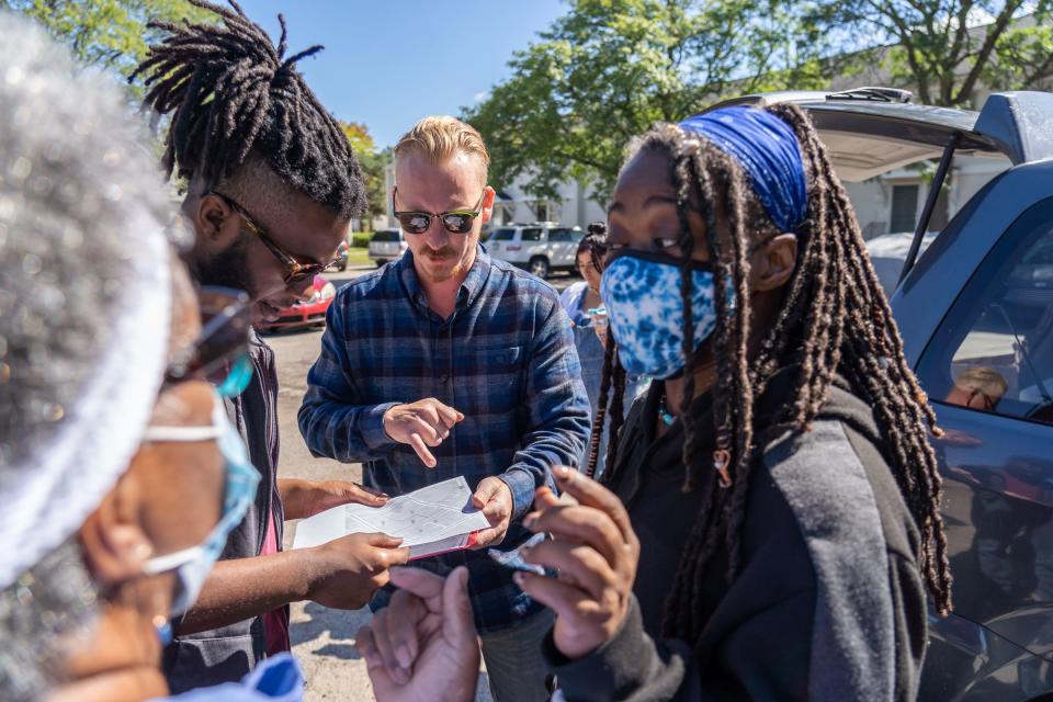 Detroit Right to Council Coalition member Evan Villeneuve (center) talks with volunteers (left to right) Geri Warren, Jerome Hunt, and Shapri Hunt while explaining the section of Martin Luther King I & II homes in Detroit where they will pass out flyers about fed rent aid to residents on Friday, September 24, 2021.