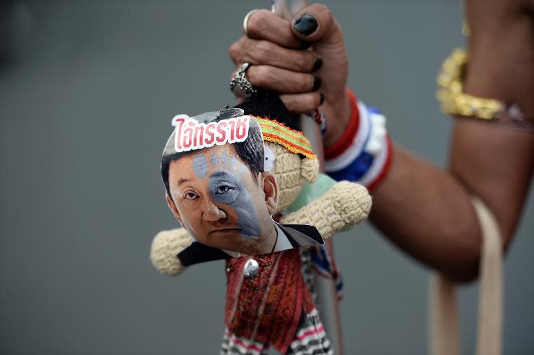 An anti-government protester carries a doll with a picture of former prime minister Thaksin Shinawatra in downtown Bangkok on February 10, 2014