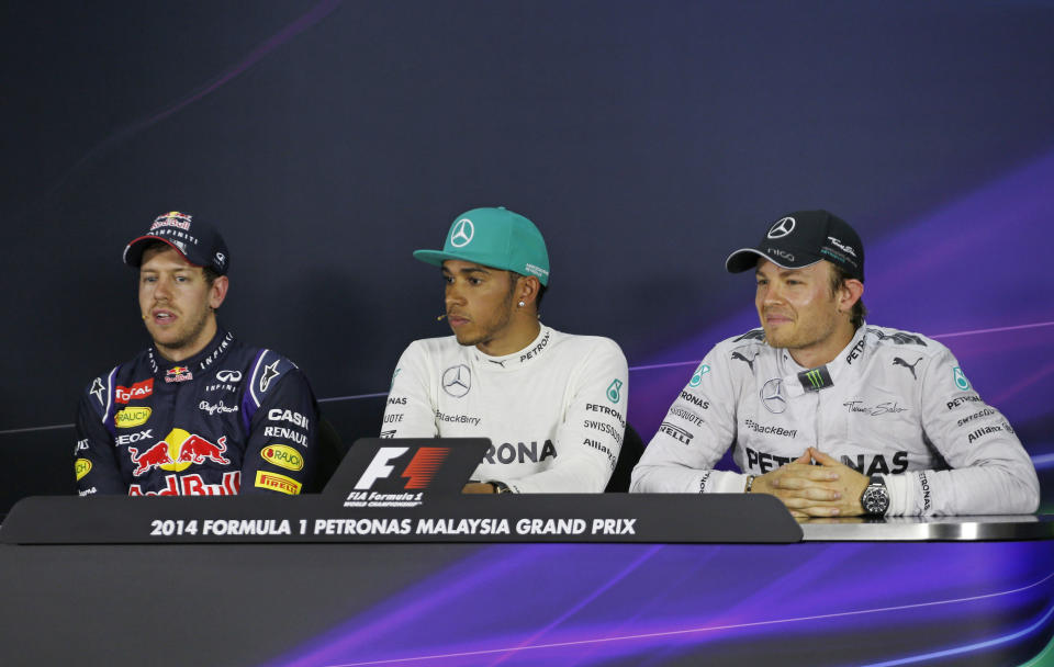 Red Bull Racing driver Sebastian Vettel, left, of Germany speaks as Mercedes drivers Lewis Hamilton, center, of Britain and Nico Rosberg, right, of Germany listen during a press conference after the qualifying session for Sunday's Malaysian Formula One Grand Prix at Sepang International Circuit in Sepang, Malaysia, Saturday, March 29, 2014. Hamilton took the pole position while Vettel with second position and Rosberg with third position. (AP Photo/Peter Lim)