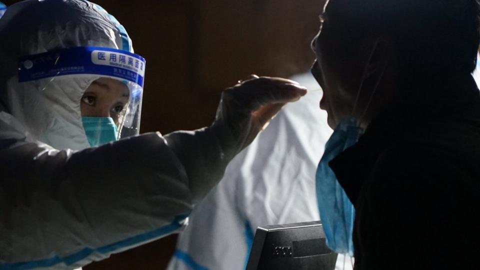 Medical workers give nucleic acid tests to people in a closed community in Xian city, China"s Shaanxi Province, China, 23 December 2021