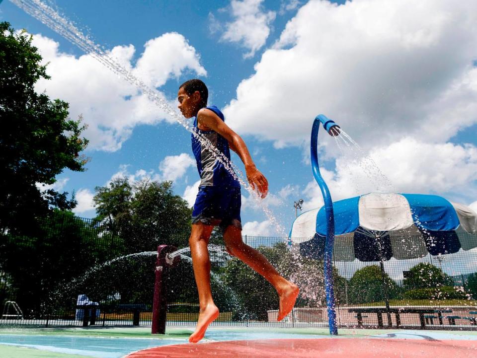 Jaylen Fuller, 12, jumps through the water at Hillside Park sprayground on Thursday, June 20, 2024, in Durham, N.C.