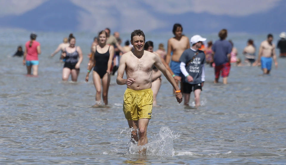 People come out of the Great Salt Lake during a gathering that fell short of making it into the record books Saturday, June 8, 2019, near Magna, Utah. Utah park officials invited people to a beach on the lake's south end in an attempt to set the world record for the largest number of people floating together, unassisted, in a line at one time. Utah State Parks manager Jim Wells said only about 300 people showed up for the event. According to the Guinness World Records website , Argentina holds the current record after 1,941 people successfully floated together on the surface of Lago Epecuén de Carhué in 2017. (AP Photo/Rick Bowmer)