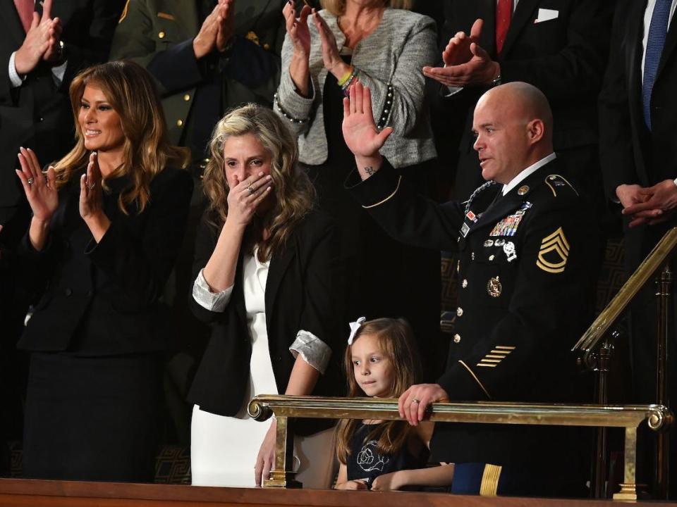 Sgt Townsend Williams (R) waves next to his children after returning from deployment in Afghanistan as his wife Amy (2L) looks on during the State of the Union address at the US Capitol in Washington, DC, on February 4, 2020.