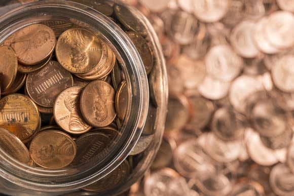 Arial view of a jar of pennies, with more pennies surrounding it.