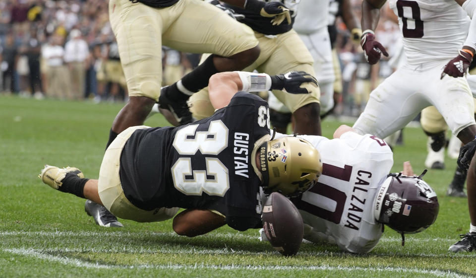 Texas A&M quarterback Zach Calzada, right, fumbles the football as Colorado linebacker Joshka Gustav makes a tackle in the end zone in the second half of an NCAA college football game Saturday, Sept. 11, 2021, in Denver. Texas A&M won 10-7. (AP Photo/David Zalubowski)