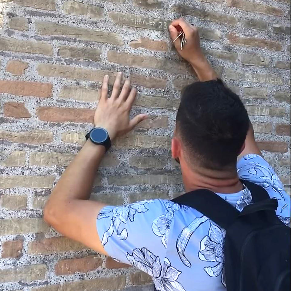 Man carves names in colosseum (YouTube)