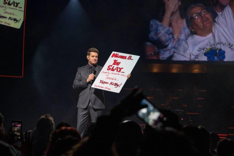 Michael Bublé holds up a sign from a fan, as a camera captures her on a screen at right, that says “Michael B… You Slay … Croon’n and swoon’n leads to spoon’n … Yippee Ki-Yay” while perfroming his Higher Tour at Golden 1 Center in Sacramento on Saturday.