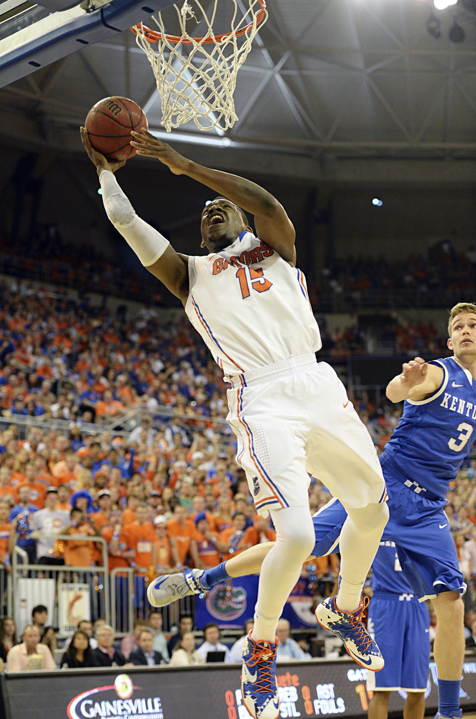 Florida forward Will Yeguete (15) goes for the basket as Kentucky guard Jarrod Polson (3) watches during the first half of an NCAA college basketball game Saturday, March 8, 2014, in Gainesville, Fla. (AP Photo/Phil Sandlin)