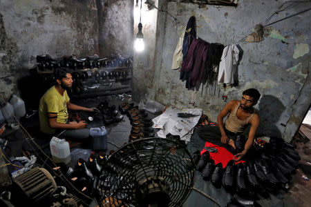Shoemakers work in an underground workshop in Agra, India, June 9, 2017. REUTERS/Cathal McNaughton/Files