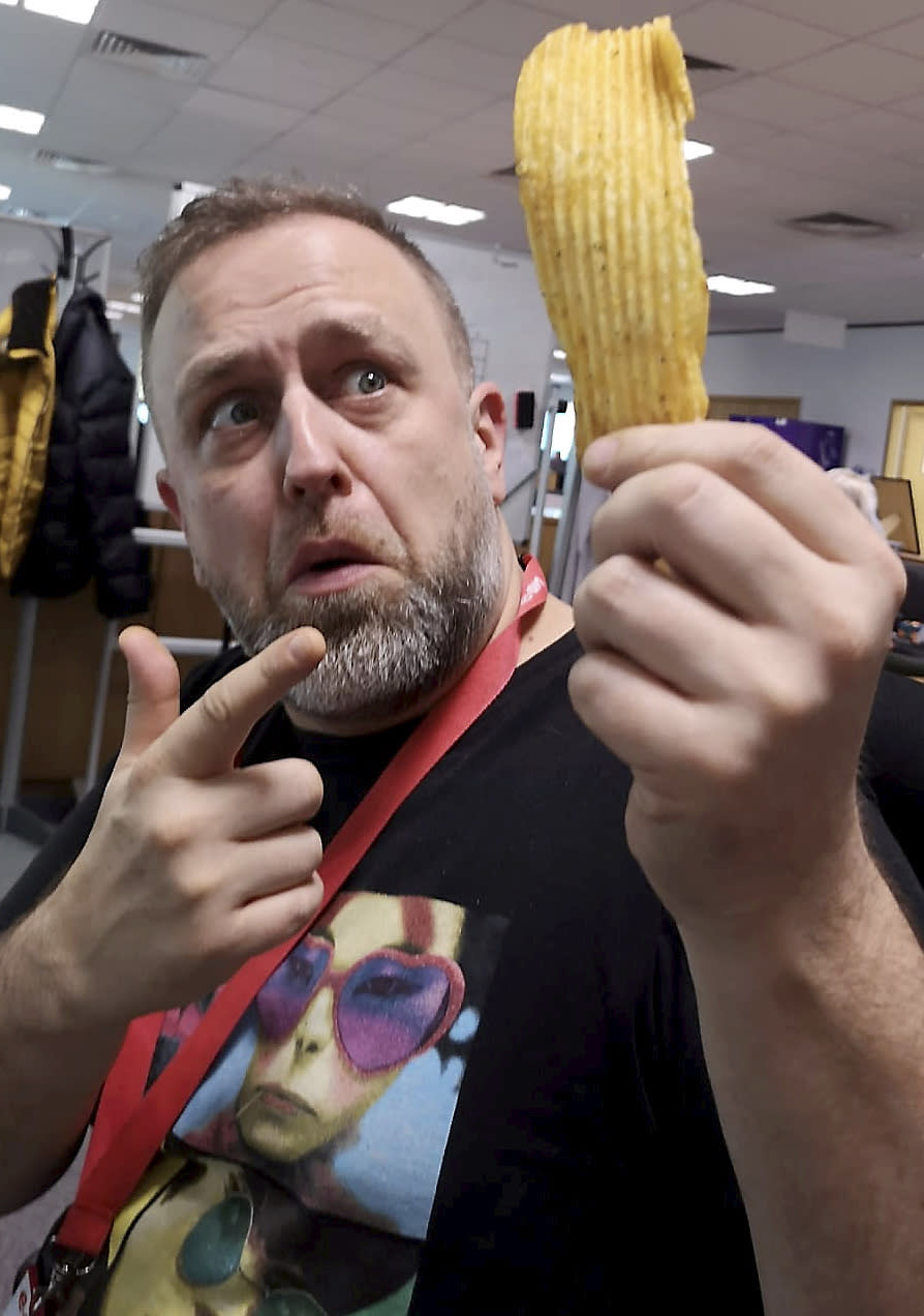 Daniel Heginbotham poses with the massive crisp (Picture: SWNS)