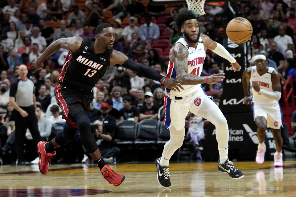 Detroit Pistons forward Saddiq Bey goes for a loose ball as Miami Heat center Bam Adebayo (13) defends during the first half of an NBA basketball game, Tuesday, Dec. 6, 2022, in Miami. (AP Photo/Lynne Sladky)