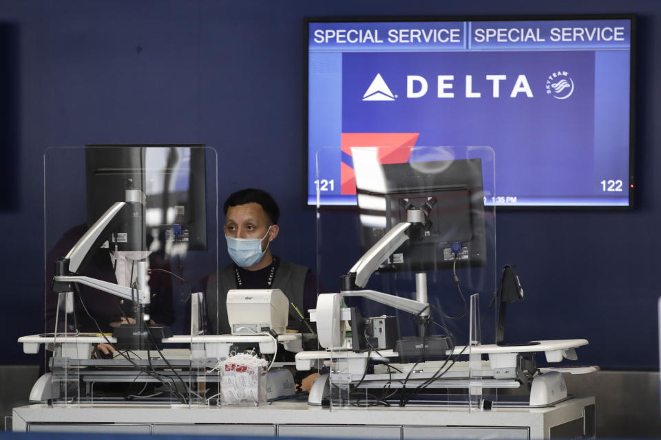 An agent works the counter at the Delta Air Lines terminal at the Los Angeles International Airport, Thursday, May 28, 2020, in Los Angeles. From Britain's EasyJet to American and Delta in the U.S., airlines are cutting even more jobs to cope with a crushing drop in air travel caused by the coronavirus. (AP Photo/Marcio Jose Sanchez)