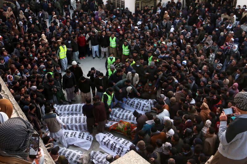 People and family members gather to identify the bodies of their relatives, who were coal miners and got killed by unidentifyed persons in Mach area of Bolan district, in Quetta,