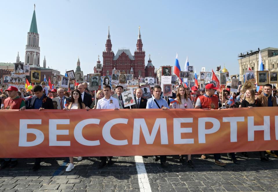 Russian President Vladimir Putin, center, holds a portrait of his father Vladimir Spiridonovich Putin, in front of him, as he walks among other people carrying portraits of relatives who fought in World War II, during the Immortal Regiment march through Red Square celebrating 74 years since the victory in WWII in Red Square in Moscow, Russia, Thursday, May 9, 2019. (Alexei Druzhinin, Sputnik, Kremlin Pool Photo via AP)