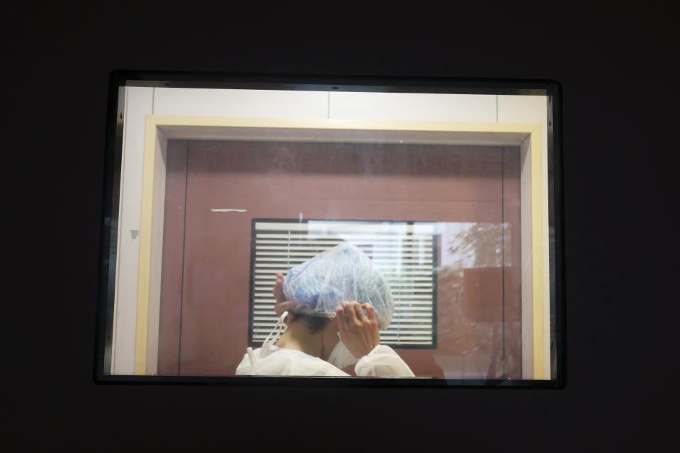 Nurse Stephanie Dias prepares to wash a patient affected by COVID-19 virus in the ICU unit at the Ambroise Pare clinic in Neuilly-sur-Seine, near Paris, Friday, March 19, 2021. French Prime Minister Jean Castex announced new coronavirus restrictions as the number of COVID-19 patients in intensive care units spikes. (AP Photo/Thibault Camus)