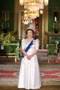 <p>The queen is photographed in the Green Room at Windsor Castle in a printed gown, diamond chandelier earrings, a silver watch, a diamond necklace, diamond bracelets, and a tiara.</p>