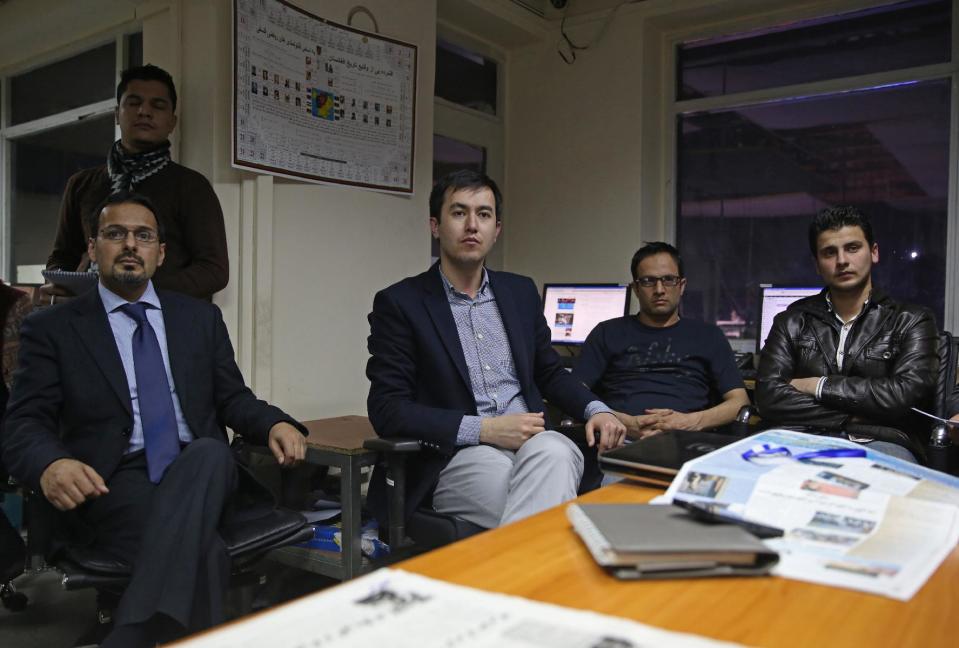 In this Monday, Feb. 3, 2014 photo, Mujahid Kakar, left, Tolo anchor and mediator of the upcoming debate and his colleagues listen during a meeting at their office in Kabul, Afghanistan. The proliferation of Afghan media in the past 12 years is one of the most visible bright spots of the fraught project to foster a stable democracy. (AP Photo/Massoud Hossaini)