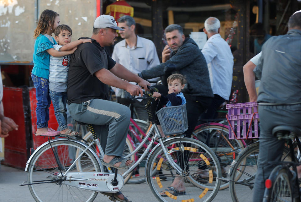 Syrian children ride a bicycle with their father at the main market, during the Muslim fasting month of Ramadan at the Al-Zaatari refugee camp June 1.