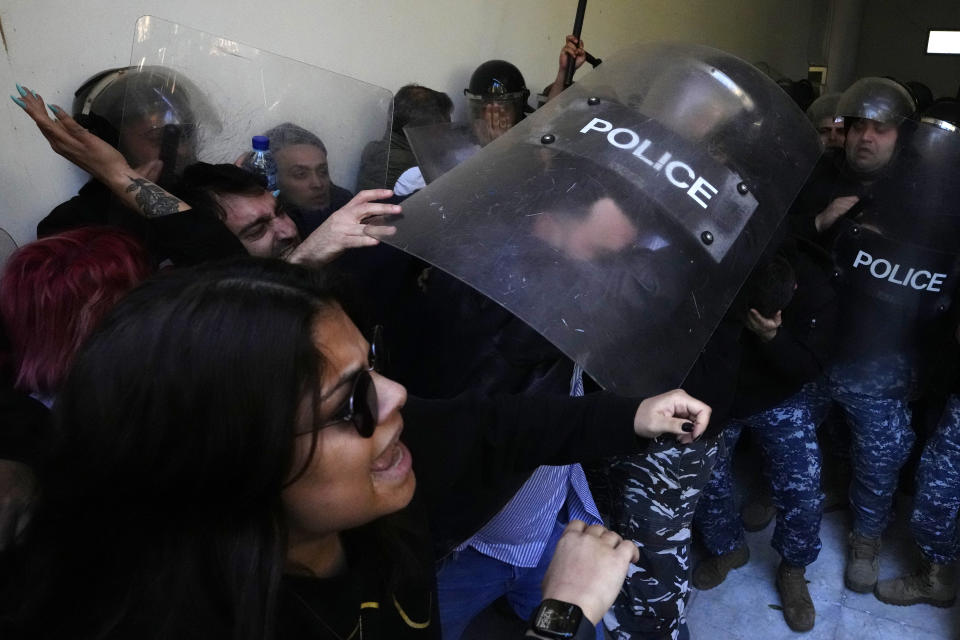 Anti-government protesters scuffle with riot police outside the ministry of Justice, in Beirut, Lebanon, Thursday, Jan. 26, 2023. Scores of protesters Thursday scuffled with riot police as they tried to break into the Beirut Justice Palace, rejecting an order from Lebanon's judiciary that further crippled the probe into a massive port explosion over two years ago. (AP Photo/Hassan Ammar)