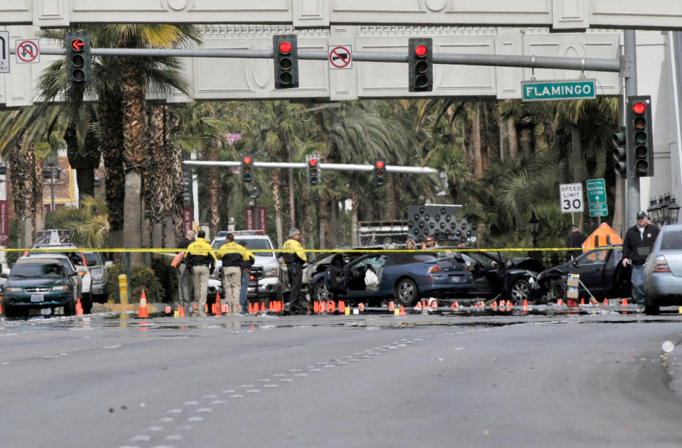 LAS VEGAS, NV - FEBRUARY 21: Las Vegas Metropolitan Police Department officers investigate the site of what is being described as a gun battle between shooters in vehicles along the Las Vegas Strip on February 21, 2013 in Las Vegas, Nevada. According to reports gunshots were fired between a black SUV and a Maserati, causing the Maserati to crash into a taxi that burst into flames. Five vehicles were involved in the subsequent crash with the Maserati driver and two people in the taxi being killed. (Photo by David Becker/Getty Images)