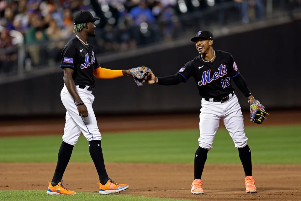 New York Mets' Francisco Lindor (12) taps gloves with Ronny Mauricio after they turned a double play against the Seattle Mariners during the third inning of a baseball game Friday, Sept. 1, 2023, in New York.