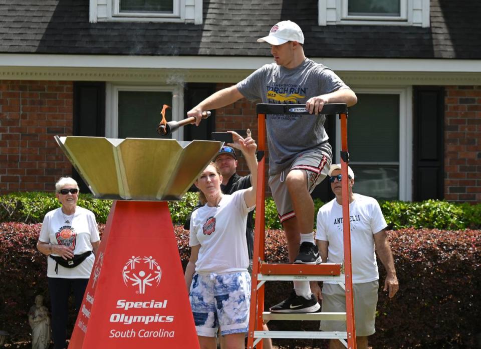 Former North Carolina State women’s basketball player and current college basketball analyst Debbie Antonelli’s son, Frankie, lights the Special Olympics cauldron at the family’s home on Saturday, May 13, 2023. Antonelli hosted her 24 Hours of Nothing But Net event where she shoots and makes 100 free throws every hour for 24 hours.