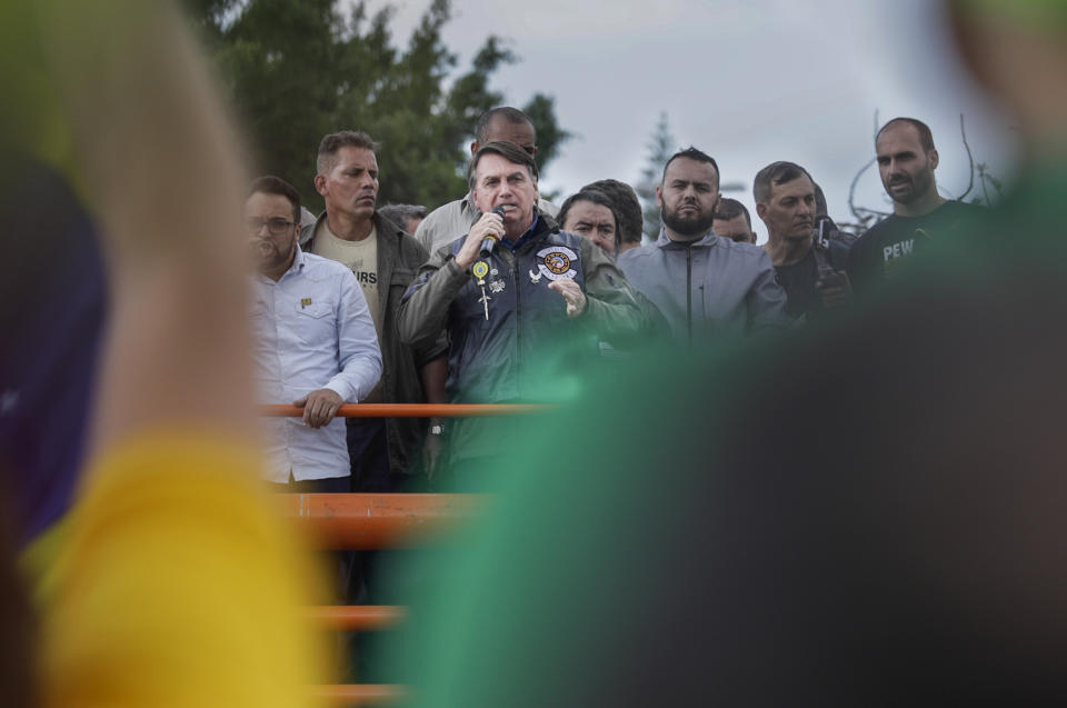 Brazil's President Jair Bolsonaro talks to supporters after joining a caravan of motorcycle enthusiasts through the streets of the city, organized to show support for Bolsonaro, in Sao Paulo, Brazil, Saturday, June 12, 2021. (AP Photo/Marcelo Chello)