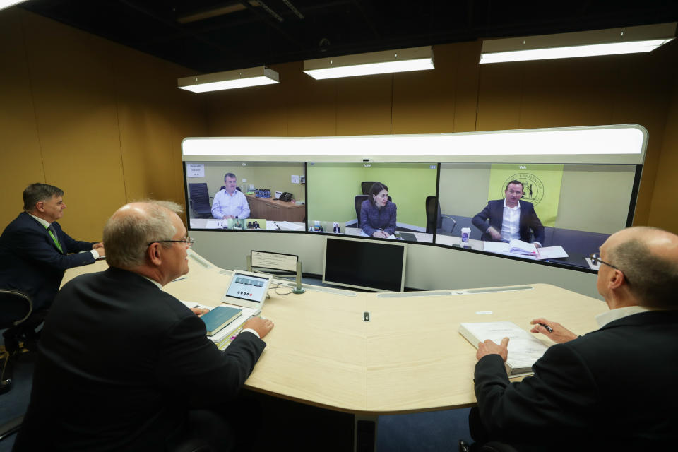 Foreground L-R: Chief Medical Officer Professor Brendan Murphy, Prime Minister Scott Morrison and Phil Gaetjens, Secretary of the Department of Prime Minister and Cabinet, speak with (on screen L-R) Jim McDowell, Chief Executive of the South Australia Department of Premier and Cabinet, Premier of NSW Gladys Berejiklian and Premier of Western Australia Mark McGowan during a National Cabinet meeting with state and territory leaders to discuss the COVID-19 (coronavirus) pandemic and the government's response at Parliament House in Canberra, Friday, May 1, 2020. (AAP Image/SMH Pool, Alex Ellinghausen) NO ARCHIVING