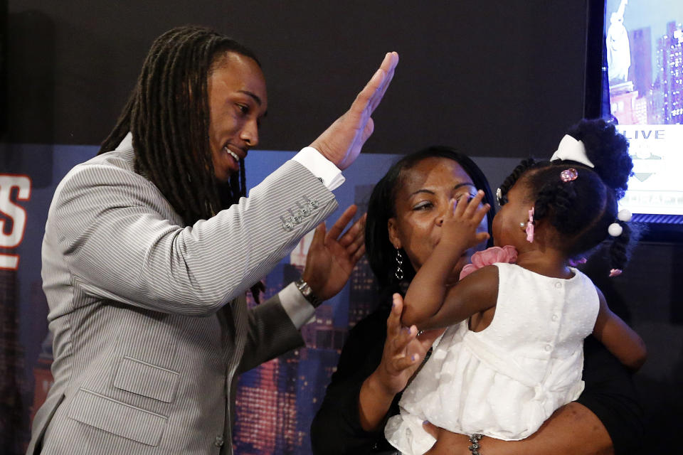 Calvin Pryor, from Louisville, high-fives with his 2-year-old daughter Jayle Exum and mother Monique Turrell after being selected 18th overall by the New York Jets in the first round of the NFL football draft, Thursday, May 8, 2014, at Radio City Music Hall in New York. (AP Photo/Jason DeCrow)