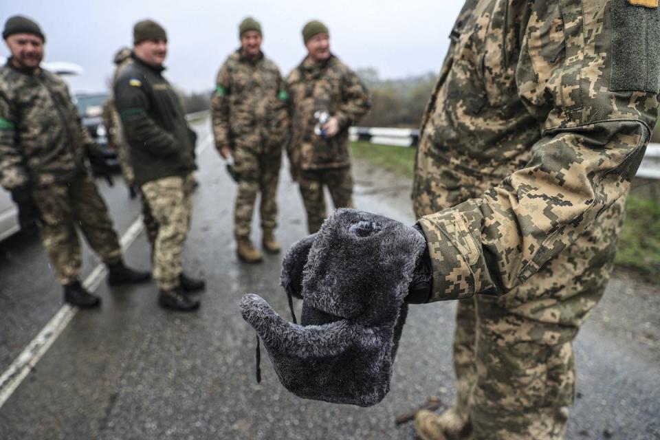 Ein ukrainischer Soldat hält eine von russischen Streitkräften nahe Kiew zurückgelassene Mütze in den Händen. 