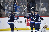 Winnipeg Jets' Kyle Connor (81) celebrates his goal against the Seattle Kraken with Mark Scheifele (55) and Gabriel Vilardi (13) during the first period of an NHL hockey game in Winnipeg, Manitoba on Tuesday April 16, 2024. (Fred Greenslade/The Canadian Press via AP)