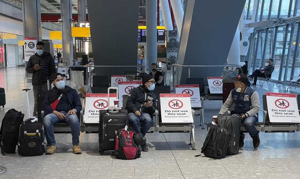 Travellers wait for their Covid-19 test results at Heathrow Airport in London, Sunday, Jan. 17, 2021. The UK will close all travel corridors from Monday morning to protect against the coronavirus, with all travellers to have a negative COVID-19 test to enter the country. (AP Photo/Frank Augstein)