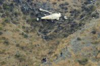 Rescue workers survey the site of a plane crashed a day earlier near the village of Saddha Batolni, near Abbotabad, Pakistan December 8, 2016. REUTERS/Faisal Mahmood