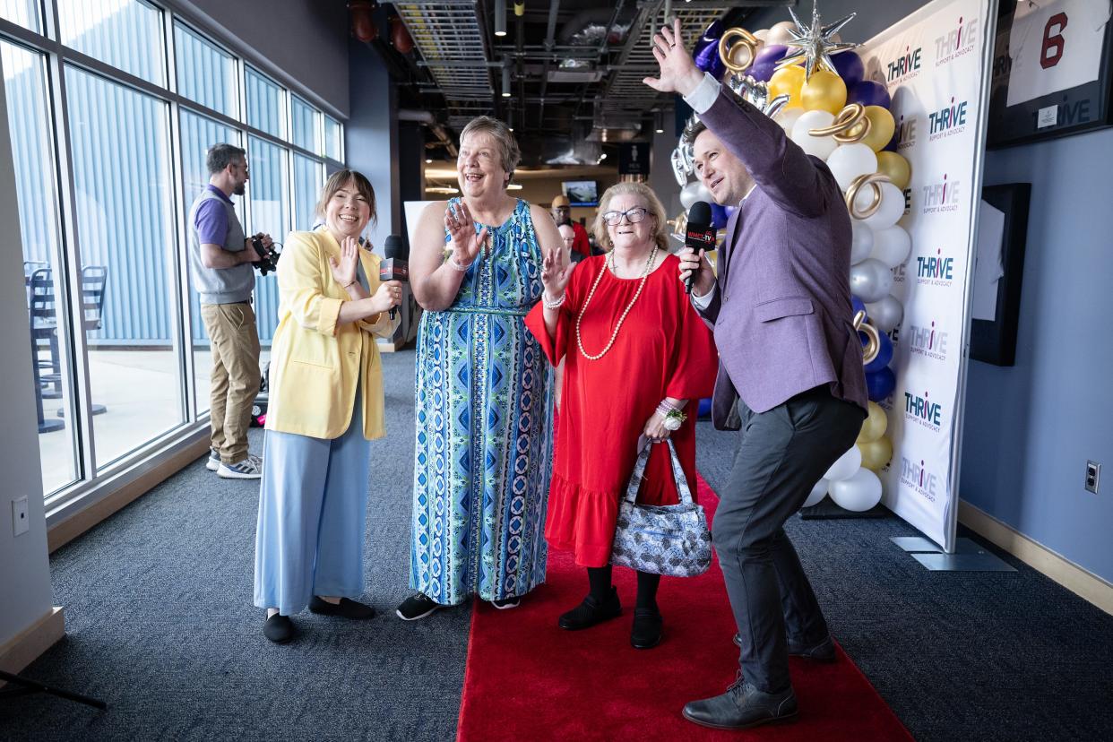 Audrey Bernie, center left, and Annie Mason, center right, give an interview on the red carpet during Thrive Support & Advocacy’s third annual Prom for All Ages Thursday at Polar Park.