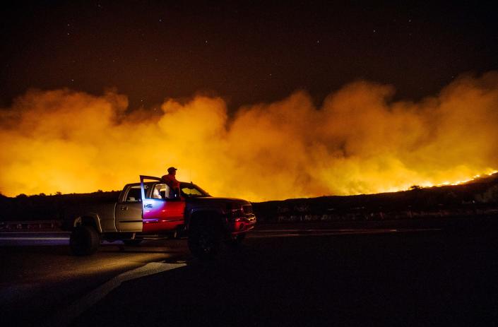 Lindsey Black from Queen Creek, Arizona, watches the Telegraph Fire burn in the Tonto National Forest near Superior, Arizona, on June 5, 2021. She was stuck in traffic on the U.S. 60.