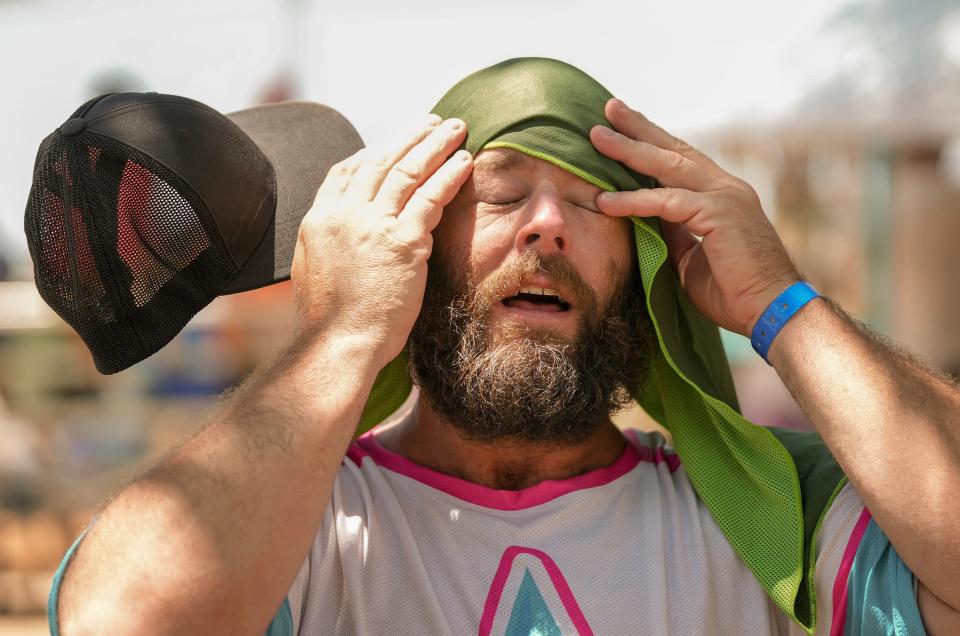 Shane Mullen, of Austin, cools off with a towel soaked in ice water at the Southwest Softball Association for the Deaf regional tournament at Walnut Creek Metropolitan Park in Austin, Texas, on a hot afternoon Friday June 23, 2023.