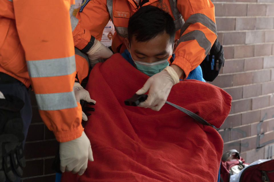 A man is evacuated by medics from the Polytechnic University in Hong Kong on Wednesday, Nov. 20, 2019. Hong Kong schools have reopened after a six-day shutdown but students were facing transit disruptions as the last protesters remained holed up on a university campus. (AP Photo/Ng Han Guan)