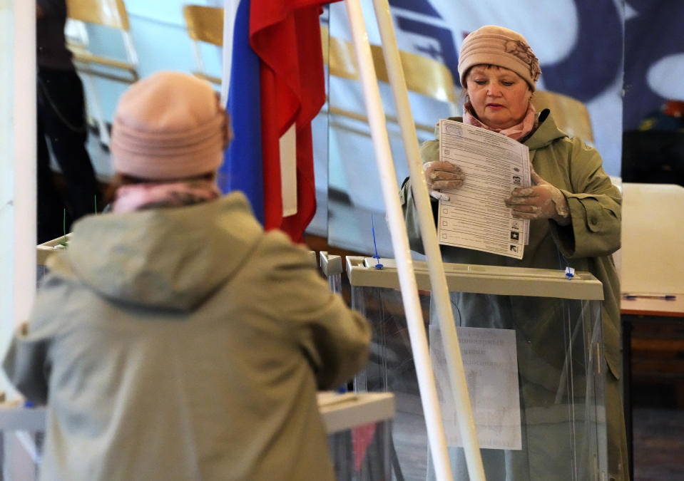 A woman reflected in a mirror casts her ballot during the State Duma, the Lower House of the Russian Parliament and local parliament elections at a polling station in St. Petersburg, Russia, Sunday, Sept. 19, 2021. Sunday will be the last of three days voting for a new parliament, but there seems to be no expectation that United Russia, the party devoted to President Vladimir Putin, will lose its dominance in the State Duma. (AP Photo/Dmitri Lovetsky)