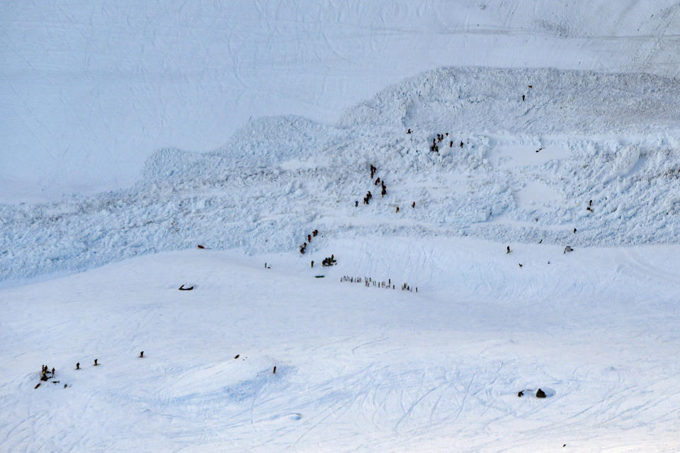 Rescue crew work on the avalanche site, at the ski resort of Crans-Montana, Switzerland, Tuesday, Feb. 19, 2019. Swiss response teams rescued at least a few people among those swept up and buried in a mid-afternoon avalanche Tuesday at the popular ski resort of Crans-Montana, police said. A frenzied search involving helicopters and rescuers “saved several people,” said spokesman Steve Leger of the Valais police, but the state of their injuries was not immediately known. (Anthony Anex/Keystone via AP)