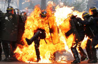 <p>MAY 1, 2017 – French CRS anti-riot police officers are engulfed in flames as they face protesters during a march for the annual May Day workers’ rally in Paris. (Photo: Zakaria Abdelkafi/AFP/Getty Images) </p>