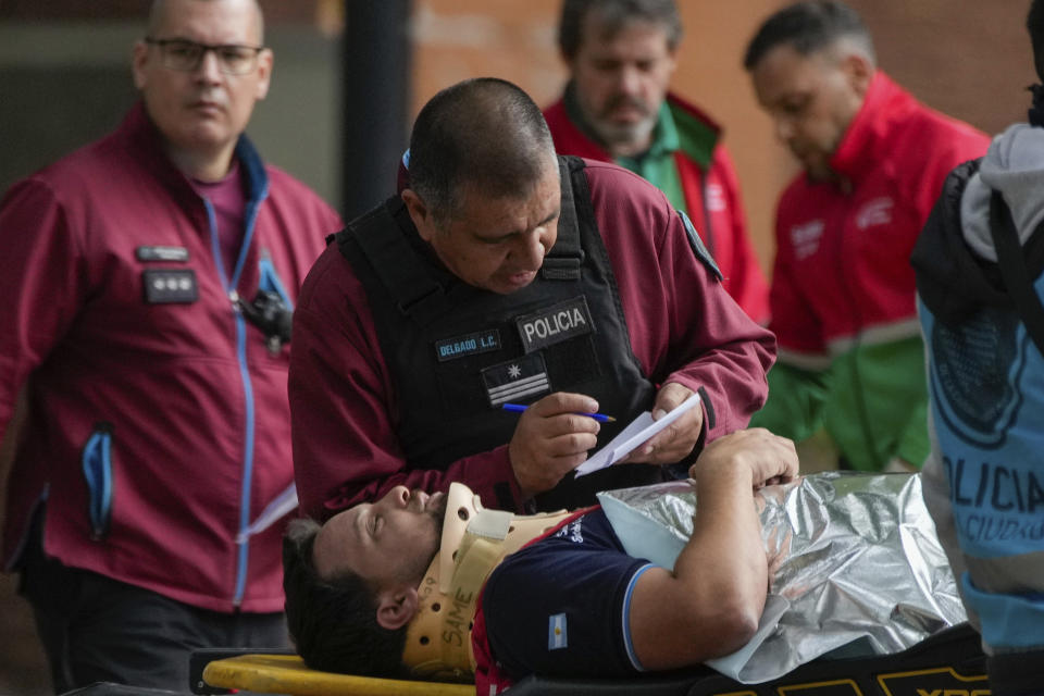 A police officer talks to a commuter who was injured when two trains collided in Buenos Aires, Argentina, Friday, May 10, 2024. (AP Photo/Natacha Pisarenko)