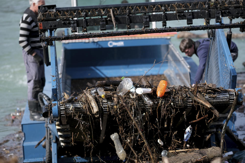 A machine collects garbage floating in the Drina river near Visegrad, eastern Bosnia, Wednesday, Feb. 24, 2021. Environmental activists in Bosnia are warning that tons of garbage floating down the Balkan country's rivers are endangering the local ecosystem and people's health. The Drina River has been covered for weeks with trash that has piled up faster than the authorities can clear it out. (AP Photo/Kemal Softic)