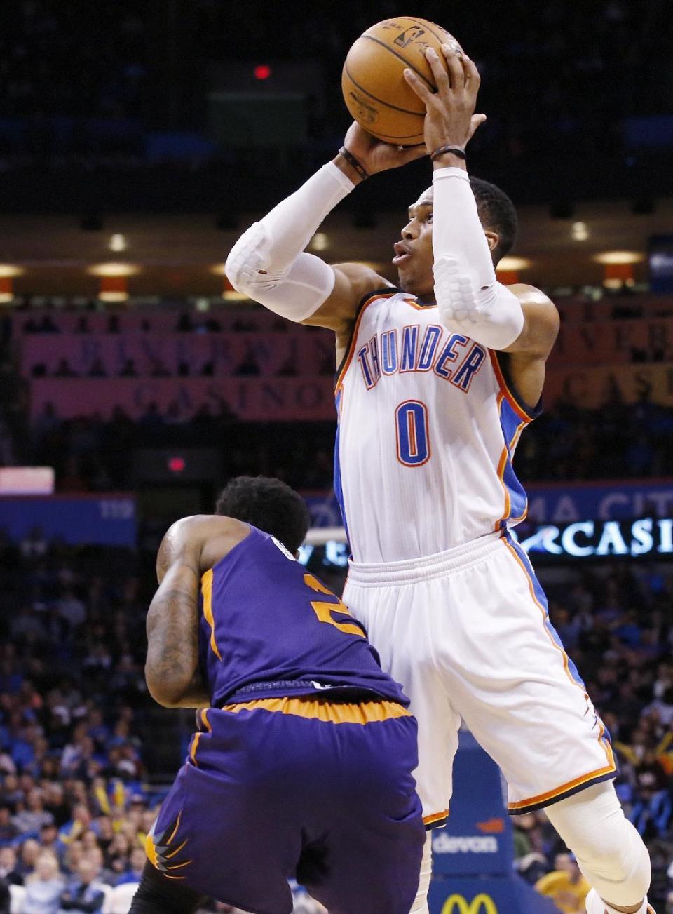 Oklahoma City Thunder guard Russell Westbrook (0) shoots per Phoenix Suns guard Eric Bledsoe (2) in the second quarter of an NBA basketball game in Oklahoma City, Saturday, Dec. 17, 2016. (AP Photo/Sue Ogrocki)