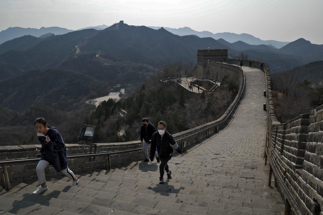 Visitors wearing protective face masks walk on the Great Wall of China after it reopened for business in Beijing, China on March 24, 2020. Beijing's city zoo and parts of the Great Wall of China have reopened to visitors who book in advance, as the capital slowly returns to normal amid a sharp fall in the number of new coronavirus cases.