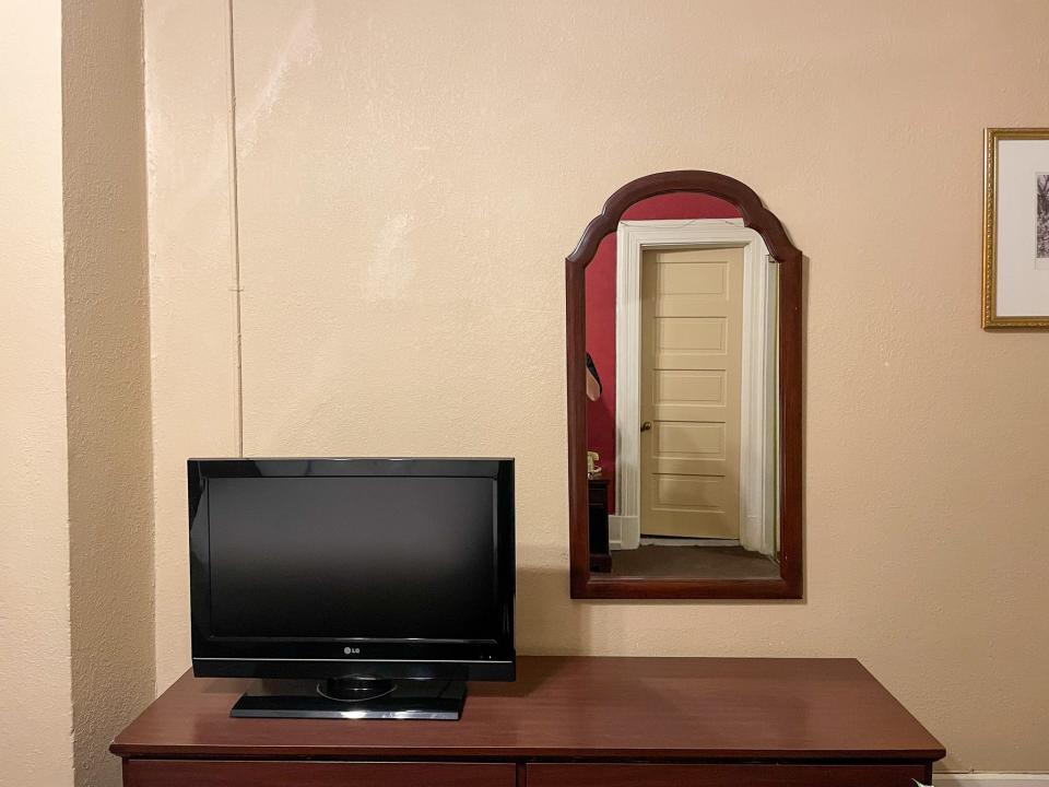 The room had a dresser, TV, and mirror.