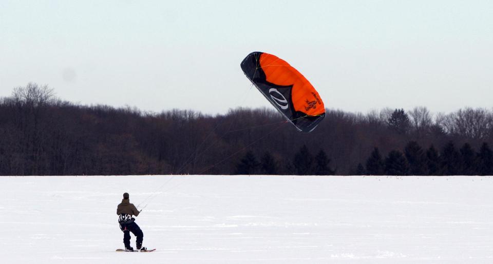 FILE - This Feb. 20, 2010 file photo shows John O'Malley, from Westchester County, N.Y, snowkiting across an open field in Cranbury, N.J. Visitors to winter recreation destinations enjoy activities like airboarding, snowkiting and skijoring as alternatives to more traditional snow sports such as skiing or snowboarding. (AP Photo/Jim Gerberich, file)