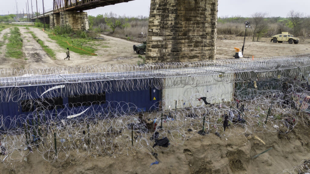 In an aerial view, a Texas National Guard soldier walks past a barrier of shipping containers and razor wire at the U.S.-Mexico border on March 17, 2024, in Eagle Pass, Texas. (John Moore/Getty Images)